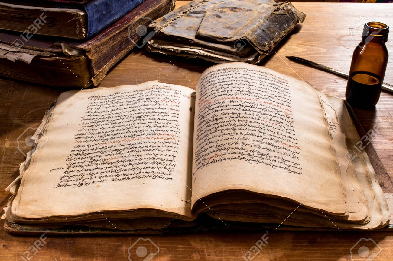Libro antiguo abierto con pluma y tinta